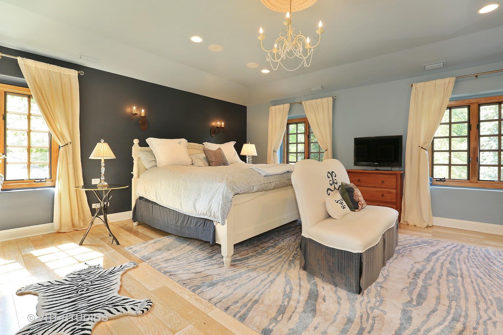 39 Mockingbird Lane Oak Brook, IL 60523 - Photo 16 of 45 a spacious bedroom with a bed a couch and large window with wooden floor