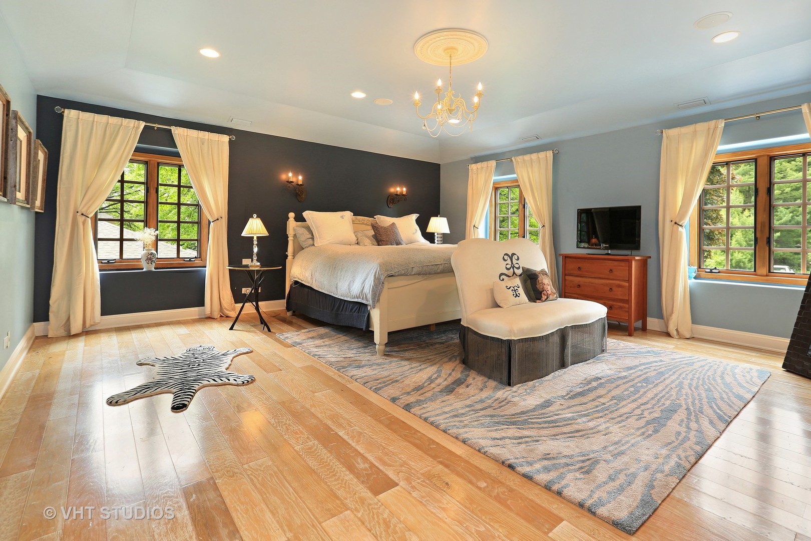 39 Mockingbird Lane Oak Brook, IL 60523 - Photo 18 of 45 a spacious bedroom with a large bed and a chandelier