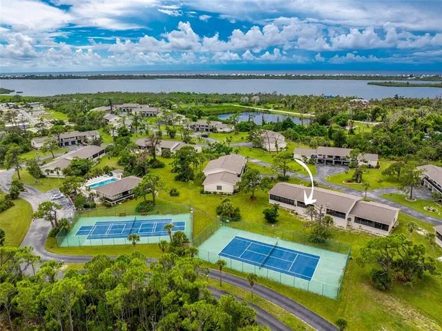 an aerial view of residential houses with outdoor space and ocean view