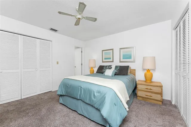 a spacious bedroom with a bed a window and a ceiling fan