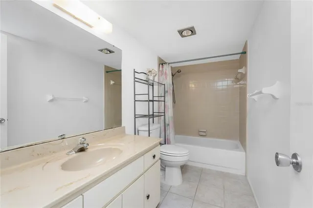 a bathroom with a granite countertop toilet a sink and bathtub