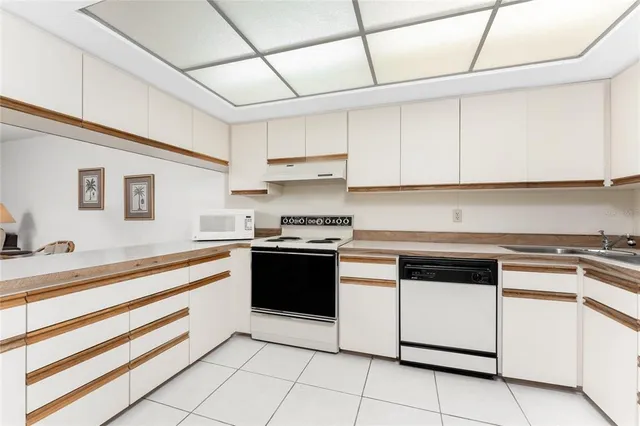 a kitchen with granite countertop white cabinets and appliances