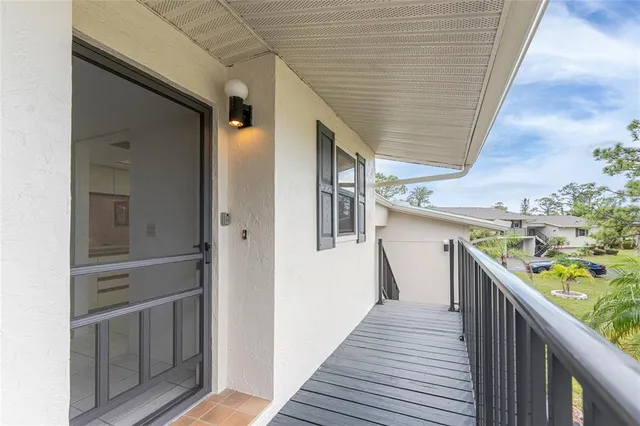 a view of a balcony with wooden floor and fence