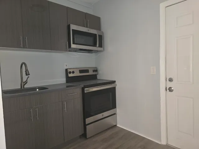a kitchen with a stove microwave and sink