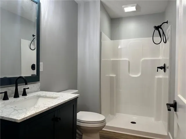a bathroom with a granite countertop sink toilet and shower