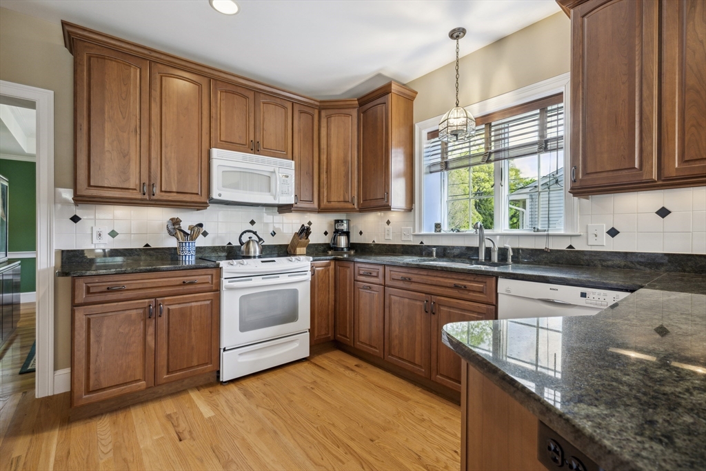 38 Lincoln Street Lexington, MA 02421 - Photo 13 of 38 a kitchen with granite countertop wooden cabinets a sink a stove a window and stainless steel appliances