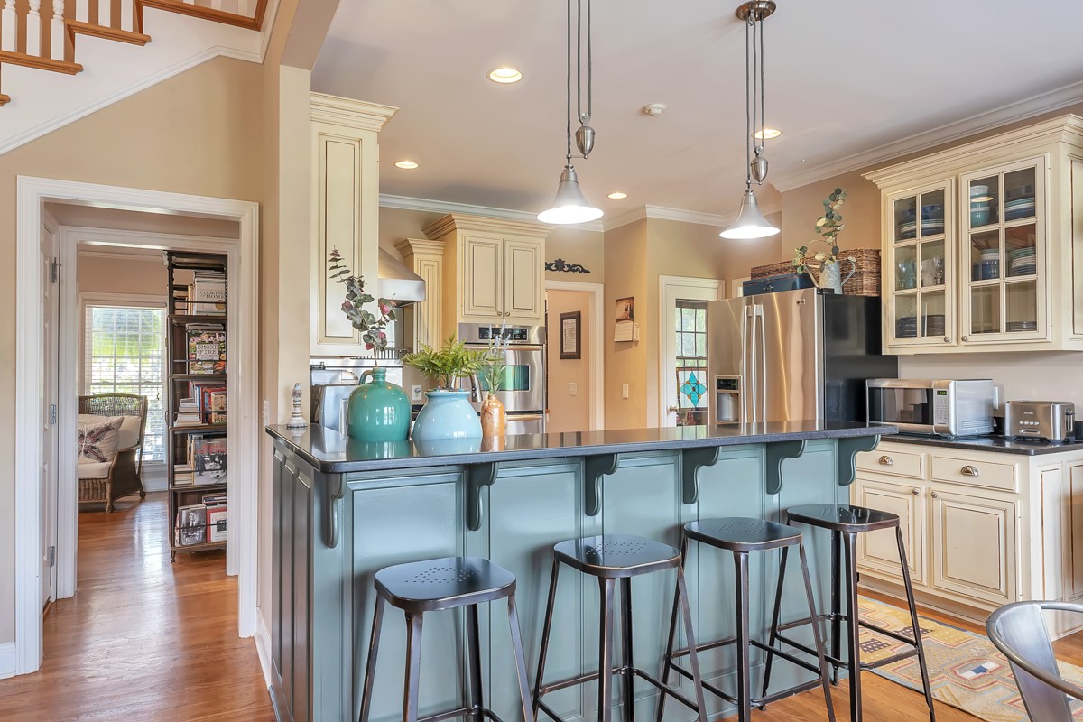 457 Bowling Branch Road Cottontown, TN 37048 - Photo 9 of 38 a kitchen with stainless steel appliances kitchen island granite countertop a table chairs in it and wooden floors