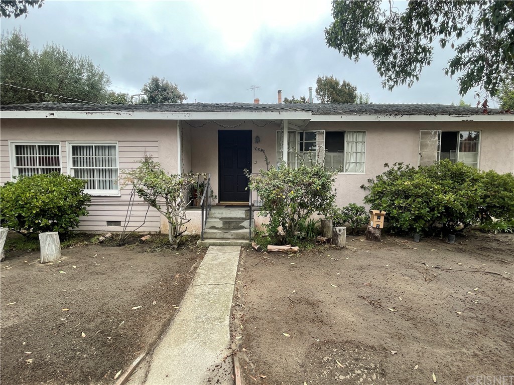 front view of house with a yard and potted plants