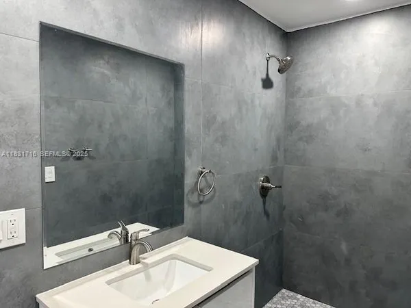 a bathroom with a sink a shower and a mirror