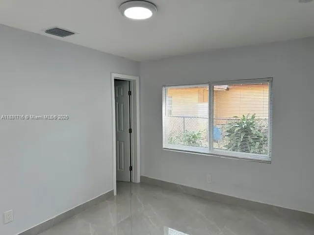 a view of an empty room with a kitchen