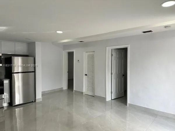 a kitchen with refrigerator and cabinets