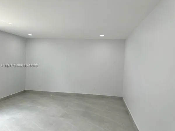 a view of a hallway with wooden shelves and a refrigerator