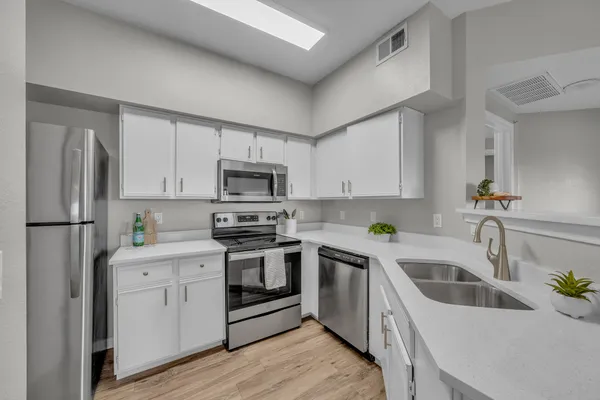 a kitchen with white cabinets and stainless steel appliances