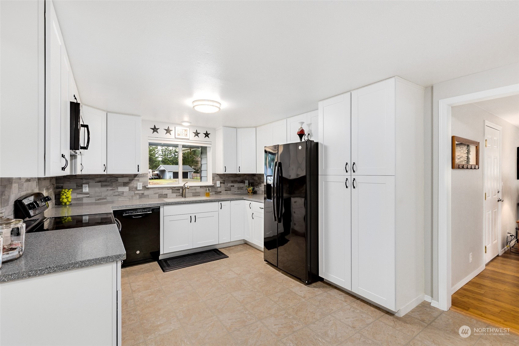 18921 Nutmeg Street Southwest Rochester, WA 98579 - Photo 8 of 32 a kitchen with a refrigerator and white cabinets