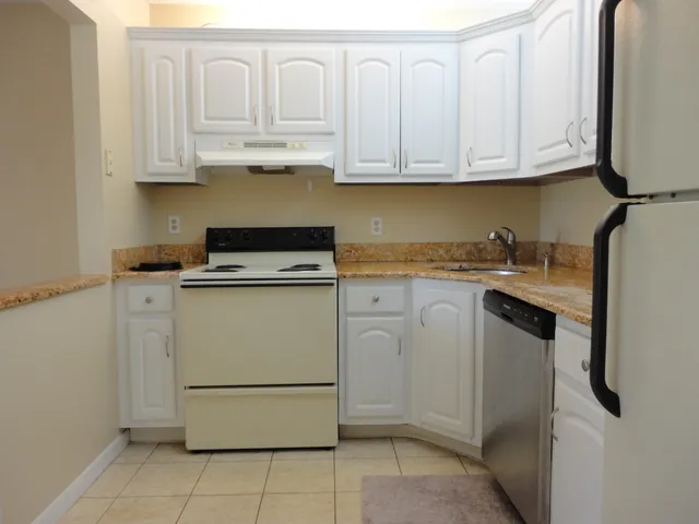a kitchen with white cabinets and white appliances