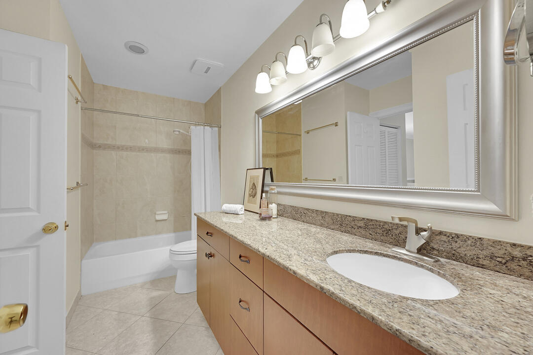 6245 Old Court Road, Unit 202 Boca Raton, FL 33433 - Photo 15 of 41 a bathroom with a granite countertop sink and a mirror a bathtub