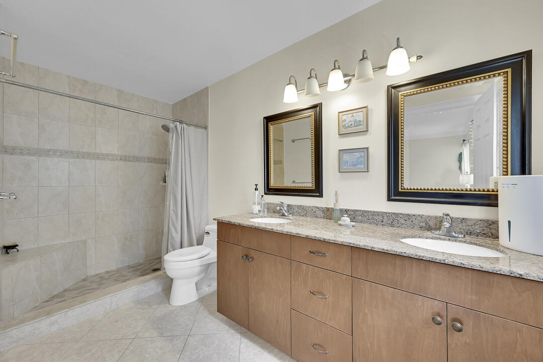 6245 Old Court Road, Unit 202 Boca Raton, FL 33433 - Photo 22 of 41 a bathroom with a toilet a double vanity sink and a mirror