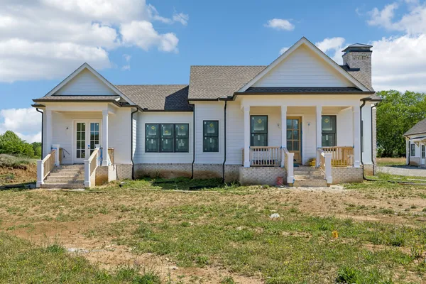 a front view of a house with a yard and seating space