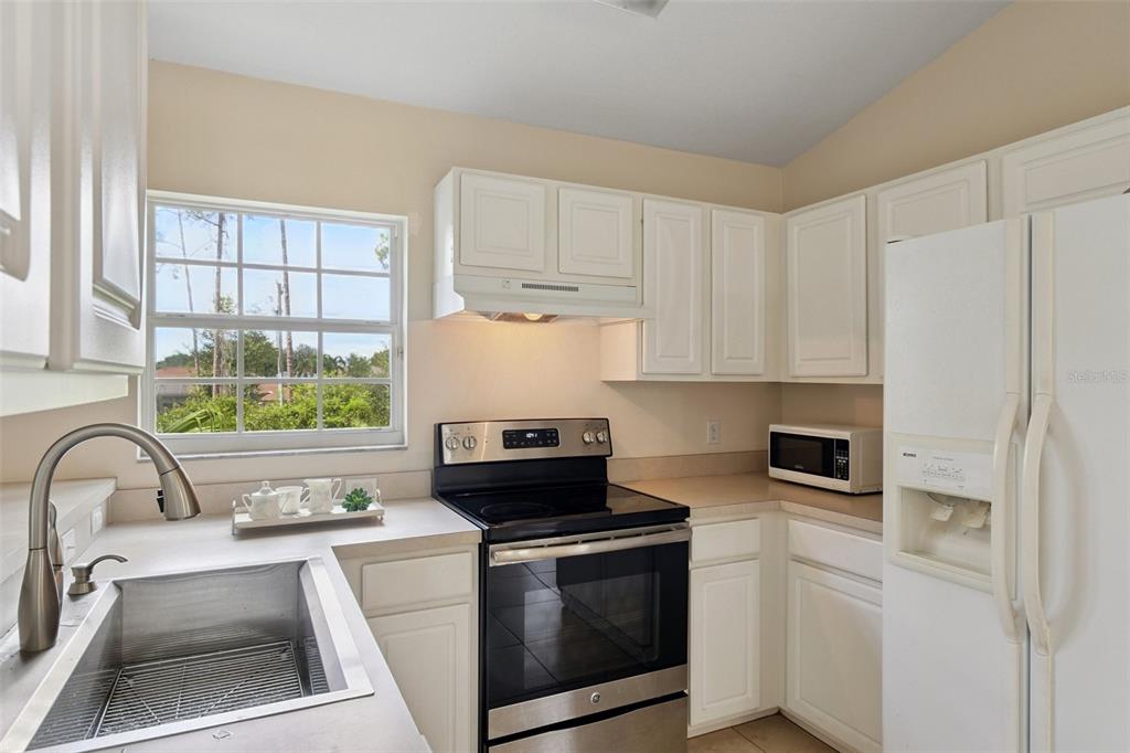 6412 Rosefinch Court, Unit 204 Lakewood Ranch, FL 34202 - Photo 21 of 33 a kitchen with a stove a sink and a refrigerator