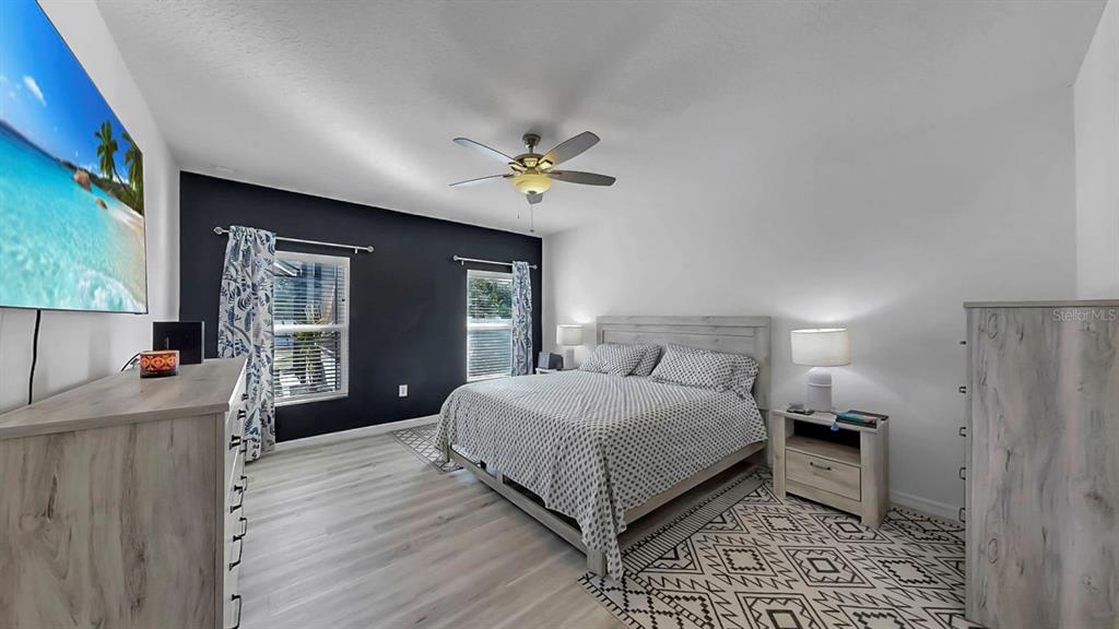 14530 Haddon Mist Drive Wimauma, FL 33598 - Photo 13 of 44 a spacious bedroom with a bed and a chandelier