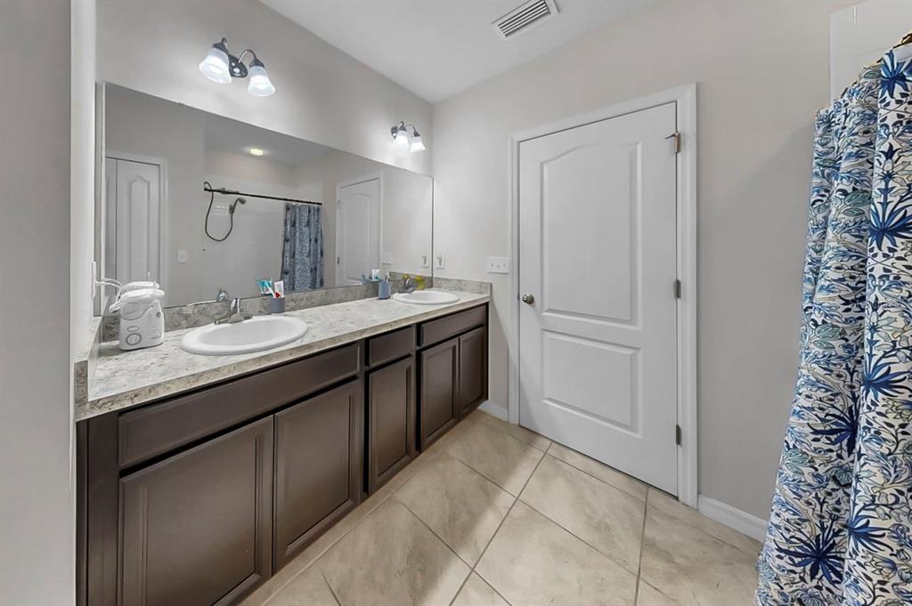 14530 Haddon Mist Drive Wimauma, FL 33598 - Photo 17 of 44 a bathroom with a granite countertop sink a mirror and a shower