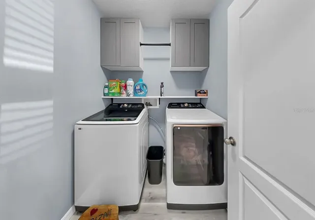 a utility room with dryer washer and sink