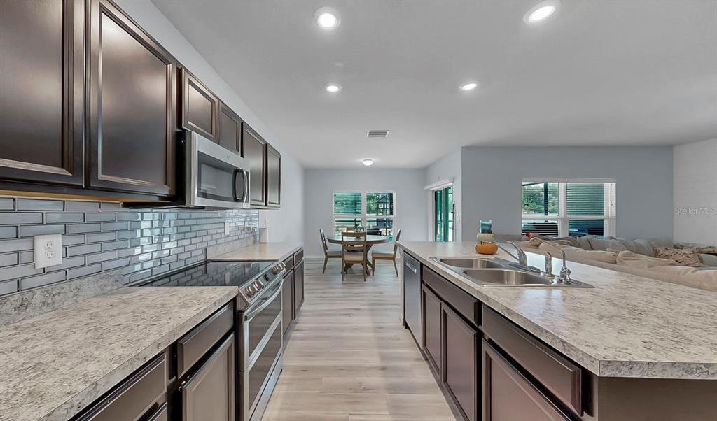 14530 Haddon Mist Drive Wimauma, FL 33598 - Photo 3 of 44 a kitchen with stainless steel appliances granite countertop counter space a sink and cabinets