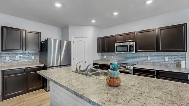 a kitchen with stainless steel appliances granite countertop a sink and a stove