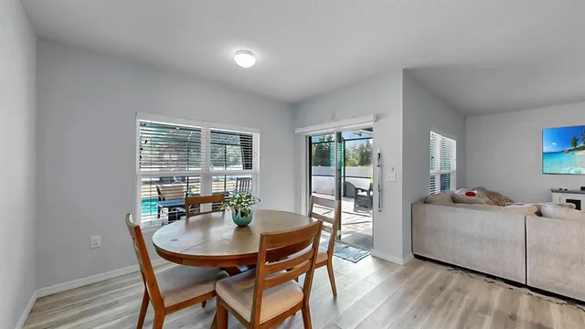 a living room with furniture a large window and wooden floor