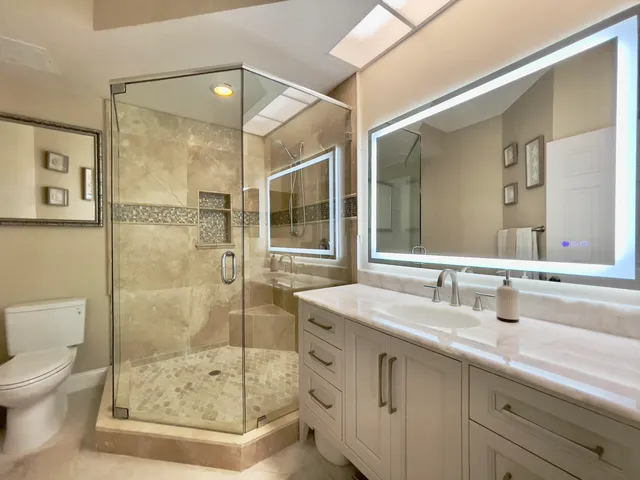 a bathroom with a shower sink mirror and toilet