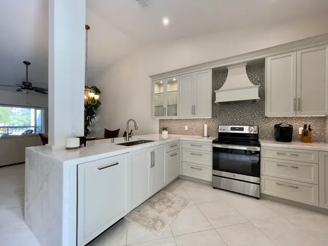 a kitchen with white cabinets and appliances