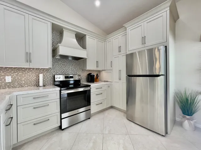 a kitchen with cabinets and white stainless steel appliances