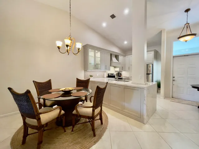 a dining room filled chandelier and kitchen view