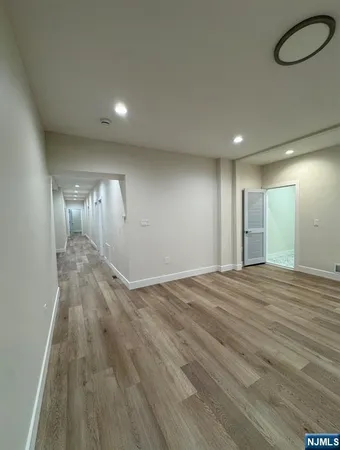 an empty room with wooden floor and mirror