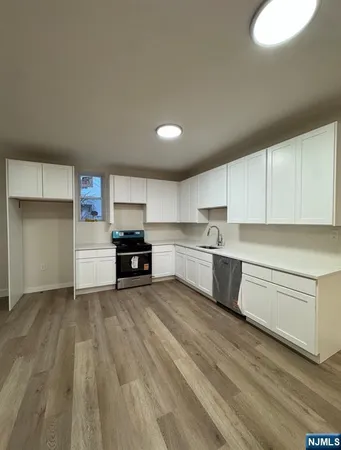 a kitchen with granite countertop white cabinets and stainless steel appliances