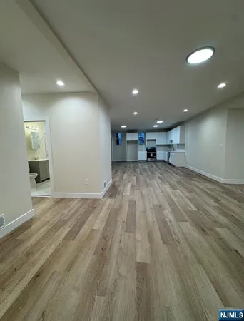 an empty room with wooden floor and natural light