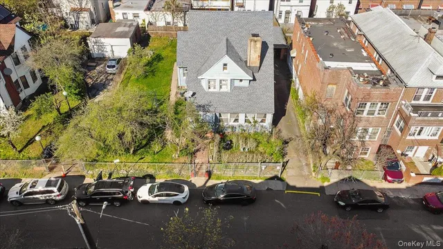 an aerial view of a residential apartment building with a yard and parking spaces
