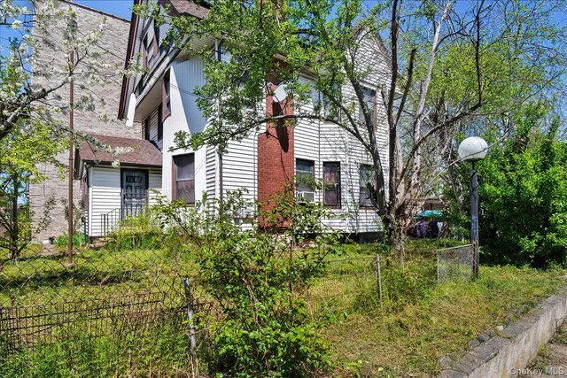 a view of a house with a yard and potted plants