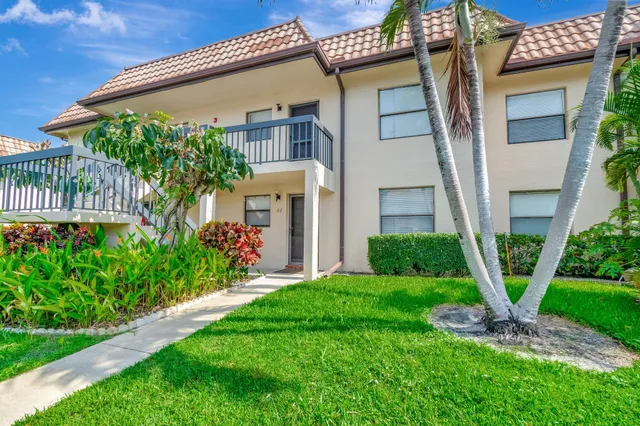 a front view of a house with a yard and potted plants