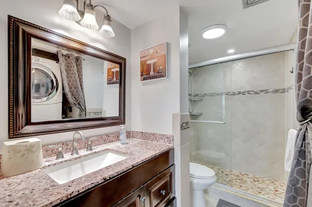 a bathroom with a granite countertop sink toilet and shower