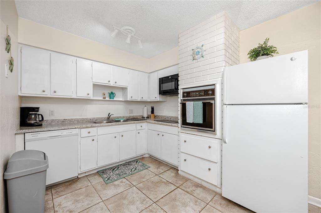 5596 100th Way North St. Petersburg, FL 33708 - Photo 49 of 67 a kitchen with granite countertop cabinets stainless steel appliances and a counter space