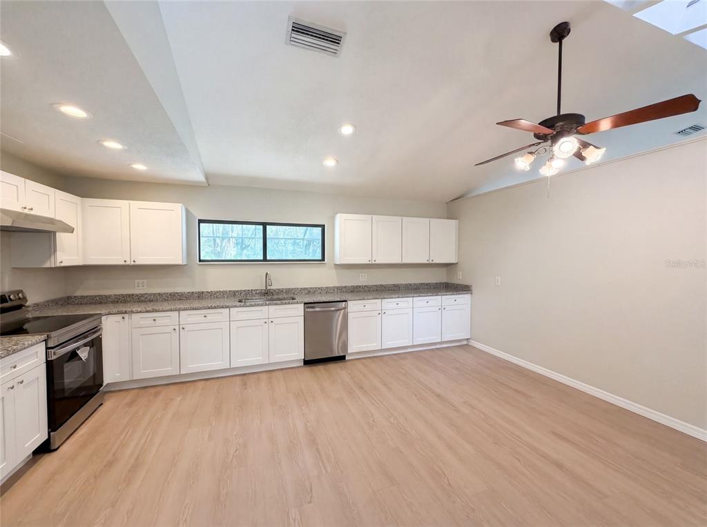 3739 Lake Griffin Road Lady Lake, FL 32159 - Photo 11 of 21 a large kitchen with stainless steel appliances granite countertop a stove and a sink