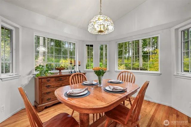 a view of a dining room with furniture a chandelier and wooden floor