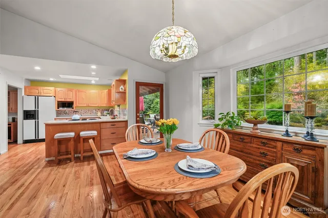 a dining room with furniture a large window and wooden floor