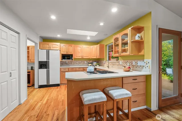 a kitchen with stainless steel appliances granite countertop a refrigerator and a stove top oven