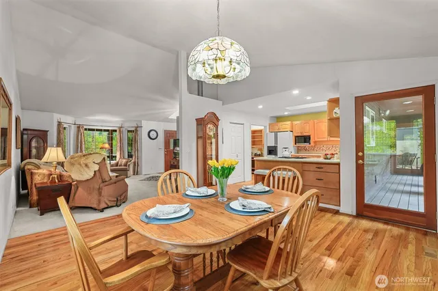 a view of a dining room with furniture a chandelier and wooden floor