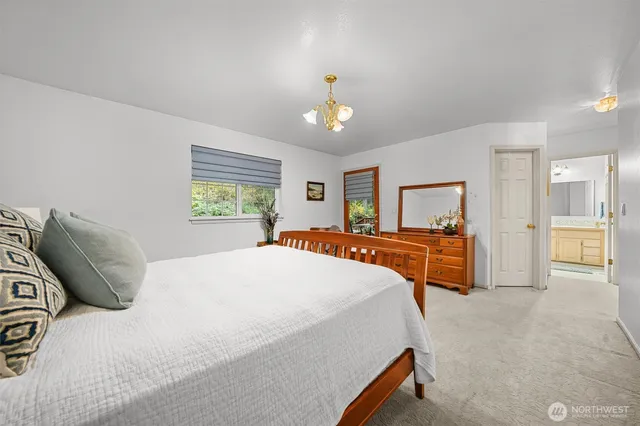 a bedroom with a large bed and a chandelier