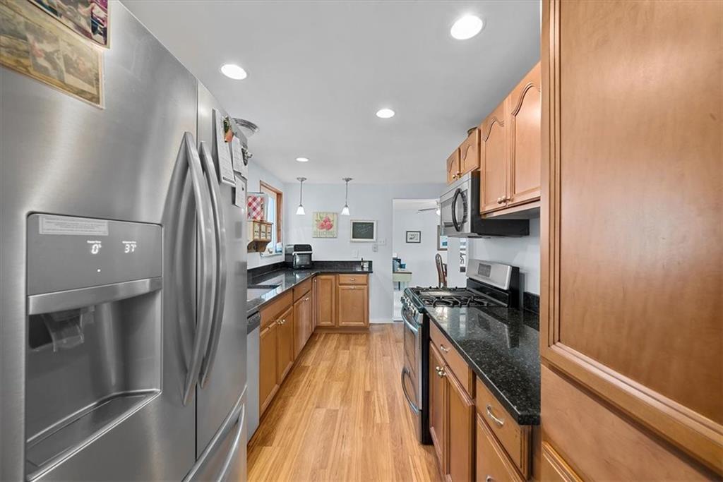 951 Highview Road Pittsburgh, PA 15234 - Photo 6 of 25 a kitchen with granite countertop a refrigerator a sink and wooden cabinets