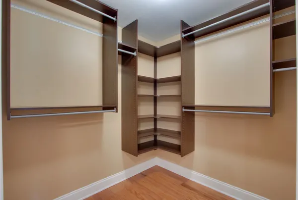 a view of walk in closet with empty racks