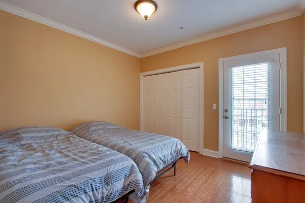 a bedroom with a bed and wooden floor